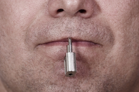 The mouth is closed with a padlock. The symbol of silence and censorship.の写真素材