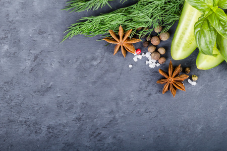 Cutted cucumber with dill and basil on the black background. Top viewの写真素材