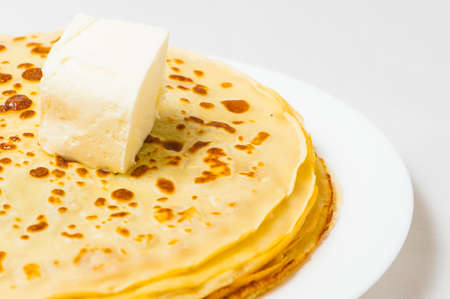 some roasted pancakes on the white plate on white background