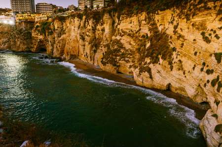 Beautiful sunset on Raouche, Pigeons Rock. In Beirut, Lebanon.Sun and Stones are reflected in water.dense clouds in the sky.の写真素材