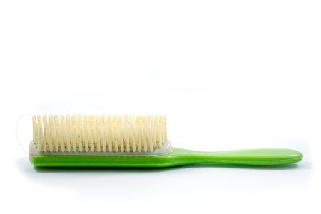 A used green hair comb has hair residue attached, this type is usually used to make it easier to comb curly hair isolated on white background.の写真素材