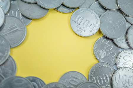 one thousand rupiah macro coins, macro coins, scattered coins and in the middle there is a yellow empty space suitable for filling in words or sentences,Suitable for Web Landing Page, Banner, Sticker.の写真素材