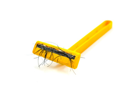 used yellow shaver has hair residue stuck to it Isolated on white background.