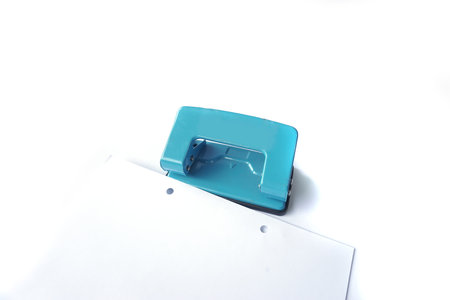 Perforator, blue hole puncher is going to punch the paper isolated on a white background.の写真素材