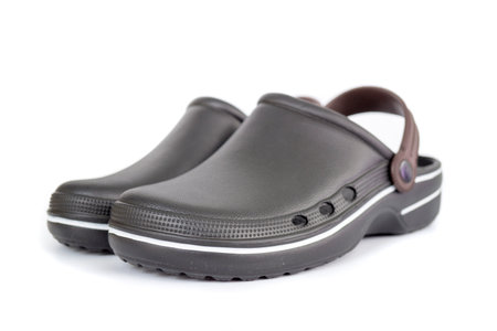 Black rubber sandals covering toes isolated on white background.