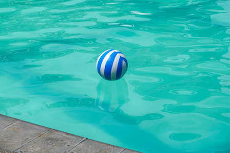 Blue and white plastic ball floating in the swimming poolの写真素材