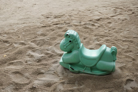 plastic horse-shaped rocking chair for toddlers in the sand.の写真素材