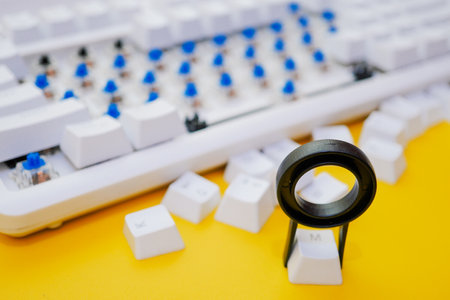 Remove mechanical keyboard keycap with tool on yellow background.