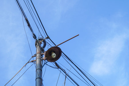 Electric poles with street lights on a blue sky background.