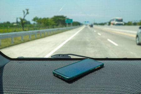 the dangers of smartphones on car dashboards in hot sunlight.の写真素材