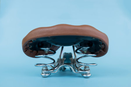 bicycle leather saddle, part of a vintage or retro bicycle, isolated on blue background.の写真素材