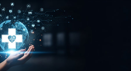 A hand gently holds a glowing digital representation of the Earth, overlaid with a large white medical cross containing a heart and pulse line. The background is dark and blurred, with abstract digital connections and light particles extending from the globe.の写真素材