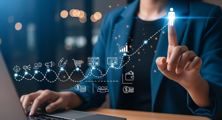 A person in a blue blazer touches a glowing upward trending graph on a digital interface. The graph is adorned with icons representing business concepts like sales, marketing, and customer acquisition, connected by a dotted line. A laptop is visible in the foreground.の写真素材