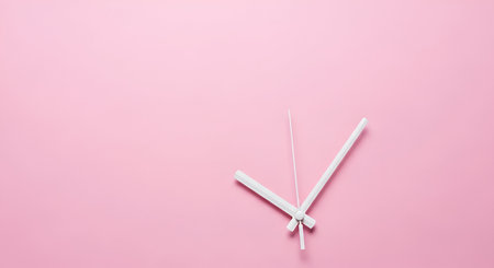A minimalist composition featuring two white clock hands, an hour hand and a minute hand, positioned at an angle on a plain, soft pink background. The hands are stark white against the pastel pink, creating a clean and uncluttered visual. The absence of a clock face emphasizes the abstract representation of time.の写真素材
