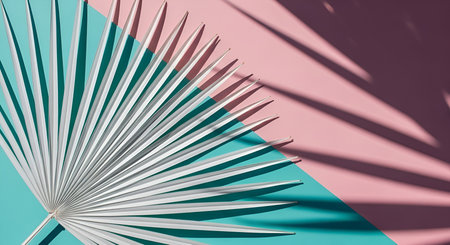 Silhouette showing palm leaf silhouette against pink and teal background keywords: palm leaf, tropical, foliage, shadow, silhouette, geometric, abstract, pastel, pink, teal, aqua, green, white, minimalist, modern, design, background, texture, pattern, light, contrast, summer, nature, plant, leaf, branch, decorative, clean, simple, graphic description: a stark white palm leaf casts a sharp shadow across a split background of pastel pink and teal. the leaf's delicate fronds fan out, creating a...の写真素材