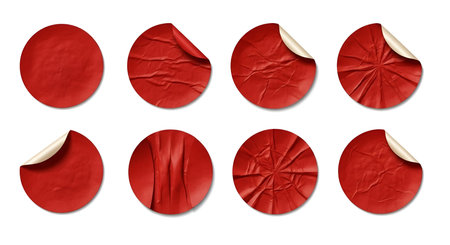 A collection of eight round, red stickers with varying degrees of wrinkling and peeling is presented on a white background. Some stickers are flat, while others show creased textures or partially lifted edges, revealing a lighter inner layer. These are graphic elements for design.の写真素材