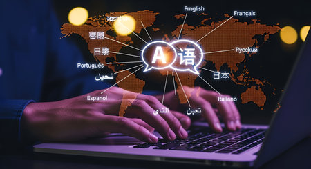 A world map is overlaid with glowing orange continents and lines radiating from a central speech bubble containing the letter 'A' and Chinese characters. Various languages like English, French, Spanish, and Japanese are labeled around the map, with a person typing on a laptop in the foreground.の写真素材