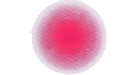 A circular shape is rendered using a halftone pattern of small pink dots. The dots are densely packed in the center, creating a solid pink core, and gradually spread out towards the edges, becoming sparser and lighter. The overall effect is a soft gradient of pink within a perfect circle on a white background.の写真素材