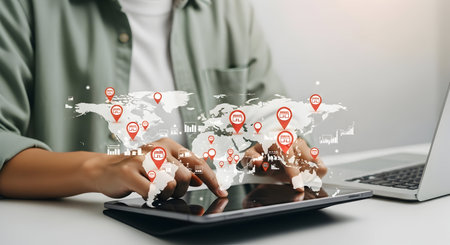 A person's hands are shown interacting with a tablet displaying a world map overlaid with numerous...
