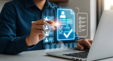 A person in a blue shirt uses a stylus to interact with a glowing blue digital interface displaying candidate profiles and a checklist. A laptop is on the right, and the interface shows multiple candidate icons and a large checkmark indicating selection.の写真素材
