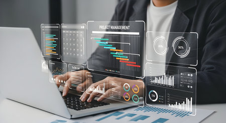 A person in a suit is shown working on a laptop with a holographic interface displaying project...