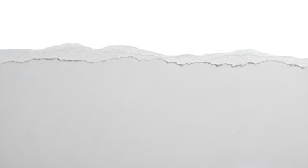 The top edge of a piece of white paper is torn and jagged, creating a textured horizontal border against a black background. The torn edge has multiple layers and a rough, irregular shape. High quality image with transparent background support.の写真素材