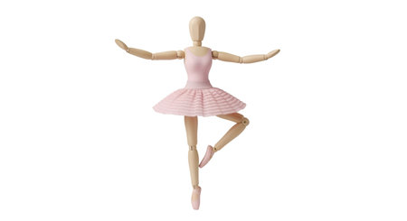 A wooden articulated artist's mannequin is captured in a graceful ballet pose, with one leg extended and arms outstretched. The mannequin is light-colored wood and wears a pink ballet tutu and slippers. It is isolated against a black background.の写真素材