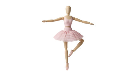 A wooden artist's mannequin is posed as a ballerina, wearing a pink leotard, a layered pink tutu, and pink ballet shoes. Its arms are outstretched, and one leg is bent at the knee while the other is extended behind. The mannequin is isolated against a black background.の写真素材