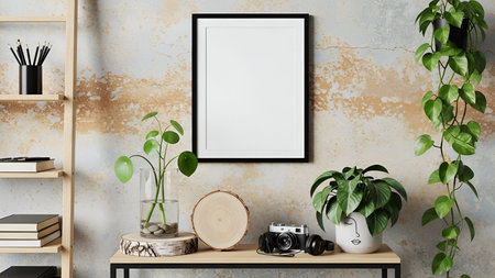Home office desk with blank picture frame and green plants on wooden table