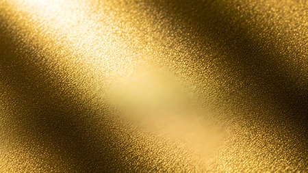A close-up, macro view of a textured golden fabric. The material has a fine, granular surface that catches the light. Bright rays of light stream across the fabric, creating strong highlights and deep shadows, emphasizing the texture and luxurious sheen. The gold color is rich and warm, suggesting opulence.の写真素材