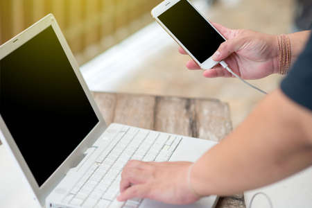 Close-up Of Female Playing Video Game On Mobile and woking computer