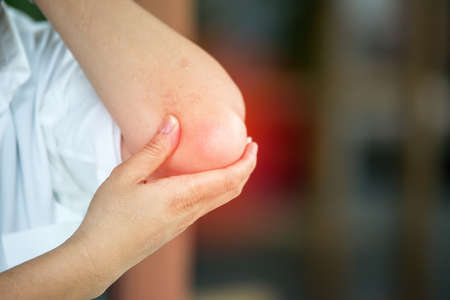 Businessman suffering from elbow pain at officeの写真素材