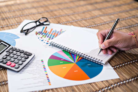 Woman writing idea for Analysis Business and financial report.