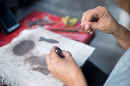 This woman is decorating the pottery on tableの写真素材