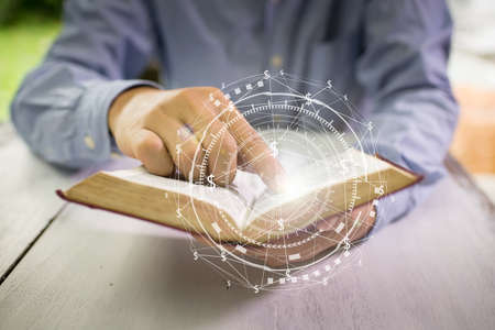 Educational Business and Technology concept. Old book in man's handsの写真素材