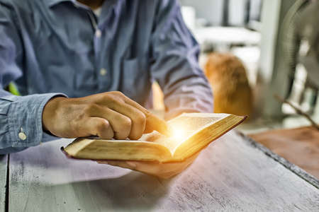 Educational concept. Old book in man's hands High Dynamic Range tone