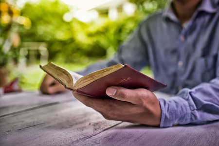 Educational concept. Old book in man's hands High Dynamic Range tone