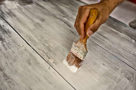 Hand with brush paint white wooden table High Dynamic Range toneの写真素材
