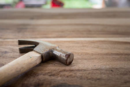 Old hammer on wood background