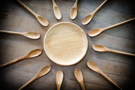 Wood dish and spoon on the wooden background. Top view conceptの写真素材