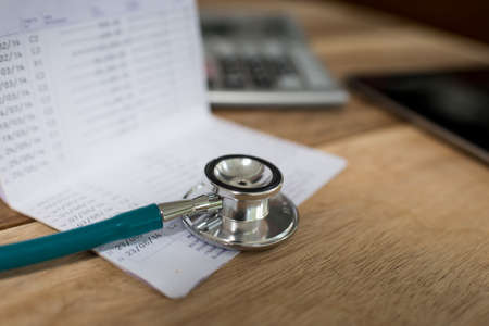 Stethoscope and book bank calculator on wood background conceptの写真素材