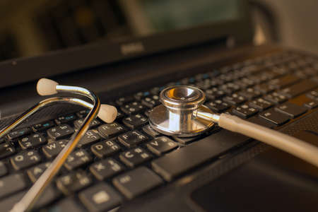 Computer or data analysis - Stethoscope over notebook keyboard vintage toneの写真素材