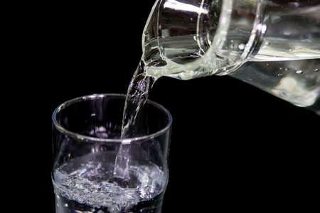 Water pouring On The Black backgroundの写真素材