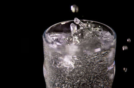Splash of water on black, Stylish water splash. Isolated on black background, bubbles in the glass,conceptの写真素材
