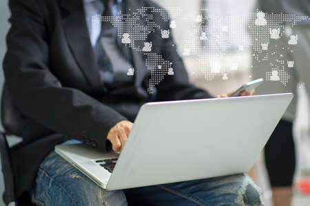 Young businessman holding working on laptop computer in , male freelancer connection worldwide conceptの写真素材