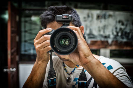 Close up portrait of photographer taking pictures with digital camera High Dynamic Range toneの写真素材