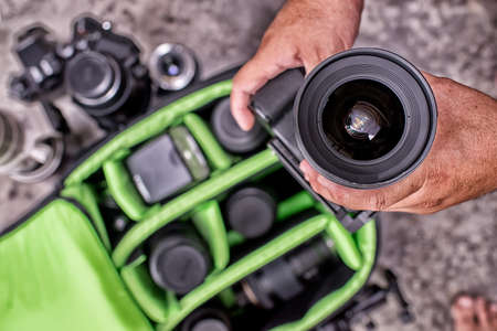 Photographer pack his camera and lenses to bagpack. Bag appliances for photography top view High...