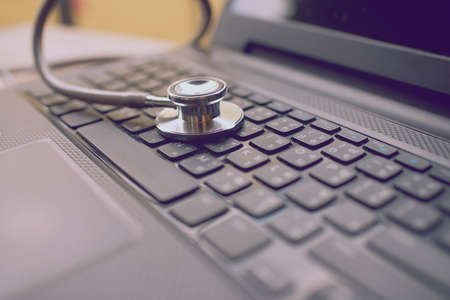 Computer or data analysis - Stethoscope over notebook keyboard vintage toneの写真素材
