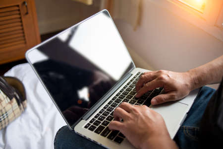 Young man working with laptop, man's hands on notebook computerの写真素材