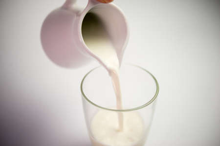 Pouring milk into glass, close upの写真素材